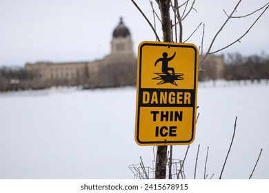 Danger thin ice warning sign on the background of the Saskatchewan Legislative Building. Frozen Wascana Lake in the city of Regina - Powered by Shutterstock