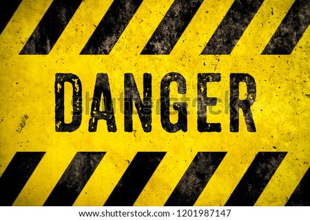 DANGER warning sign word text as stencil with yellow and black stripes painted over concrete wall cement texture background. Concept image for caution, dangerous area and hazard.
