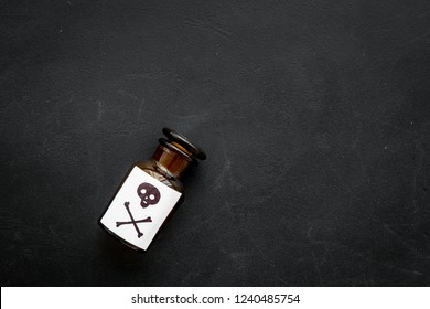 Dangerous addictions, dangerous entertainment. Poison. Bottle with skull and crossbones on black background top view space for text