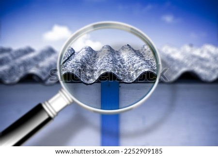 Dangerous asbestos roof panels - concept with magnifying glass