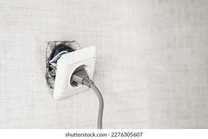 Dangerous bad,broken socket,plug in bathroom,falling out of wall. Outlet installation in old apartment. Poor electrical wire,repair.Terrible do-it-yourself repairmen.Short circuit risk,electric shock. - Shutterstock ID 2276305607