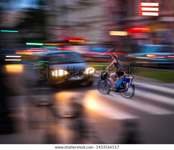 Dangerous city traffic situation\
with cyclist and car in the city in motion blur. Defocused\
image\
