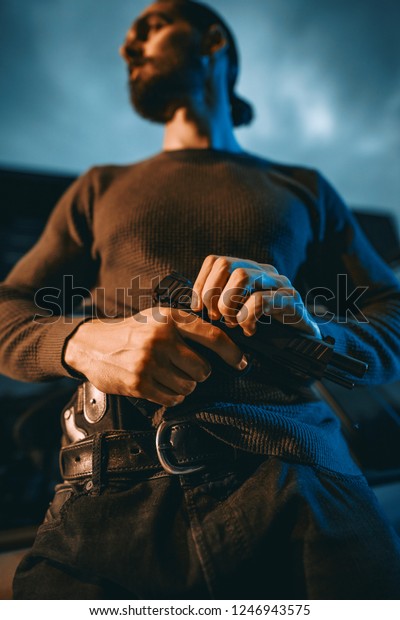 Dangerous criminal man with gun ready for the next\
murder job.