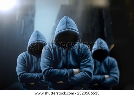 Dangerous criminal. Silhouette of bandits, criminals with an unrecognizable face in threatening pose at night on dark street. Frightening dangerous silhouettes of men. threatening rise in crime