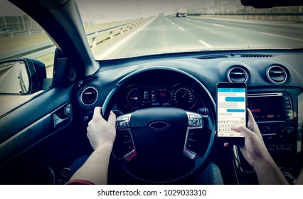 Dangerous driving while writing SMS text message - Shutterstock ID 1029033310