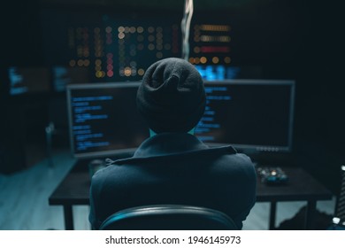 Dangerous Hooded Hacker Breaks into Government Data Servers and Infects Their System with a Virus. Hideout Place has Dark Atmosphere. Wanted programmer coding virus ransomware using computers. - Powered by Shutterstock