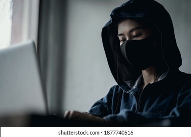 Dangerous Hooded Hacker using computers and infected virus ransomware to hacking a personal and financial data. Cybercrime, information technology, phishing mail.