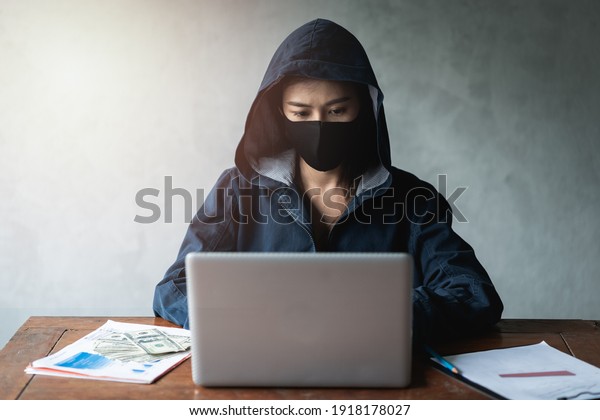 Dangerous Hooded Hacker using\
computers and infected virus ransomware to hacking a personal and\
financial data. Cybercrime, information technology, phishing\
mail.