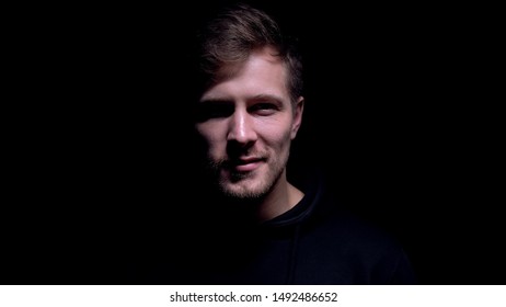 Dangerous Man With Crazy Grin Looking Into Camera Maniac Against Dark Background