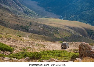 Dangerous Mountain Gravel Road With Off-road UAZ Descending In Mountain Valley. Summer Road Trip, Journey. Way To Burkhan-Bulak Waterfall. Kapalskiy Vzvoz Mountain Pass.  29.08.2021 Kapal, Kazakhstan.