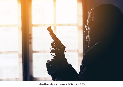 Dangerous Old Man Pointing A Gun At The Target On Dark Background, Selective Focus On Gun, Vintage Color Tone,Crime Concept