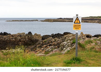 Dangerous Path Caution Sign Close To A Rocky Outcrop