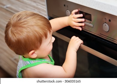 Dangerous situation in the kitchen. Child playing with electric oven. 