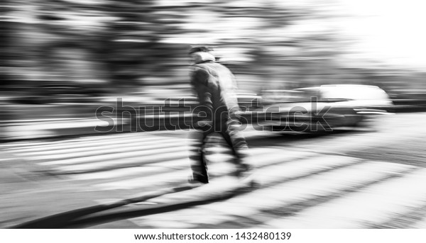 Dangerous situation on zebra crossing. Black and\
white image of an elderly man runs across the road in front of the\
car. Intentional motion blur.\
