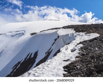 Dangerous Snow Ledge On The Top Of The Mountain. Ledges From The Snowy Mountains. Cliffs And Large Rocks. Dangerous Terrain.