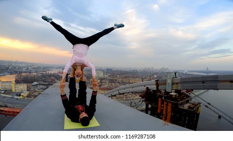 Dangerous stunts by professional athletes on top of high bridge, acro yoga poses - Powered by Shutterstock
