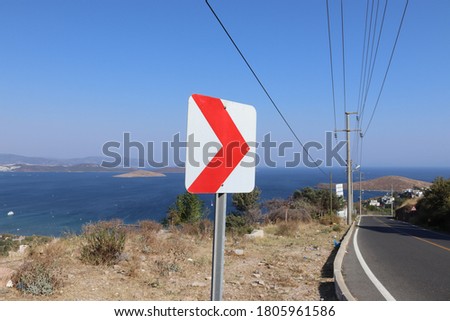 Dangerous turn right, red and white roadsign on road side