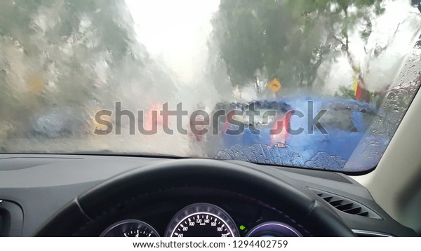 Dangerous\
vehicle driving in the heavy rain and slippery road. Abstract\
blurred bad weather car on the heavy\
traffic