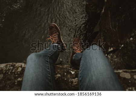 Dangling feet on a cliff