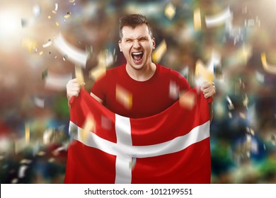 Danish Fan, Fan Of A Man Holding The National Flag Of Denmark In His Hands. Soccer Fan In The Stadium.