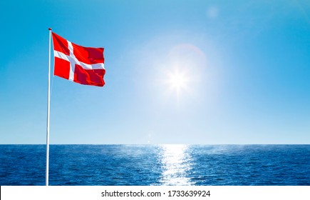 Danish flag in the wind against a blue sky