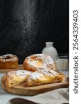 Danish pastry with icing sugar topping. With copy space. Perfect for recipe, article, catalogue, or any commercial purposes. Dark and moody style. 