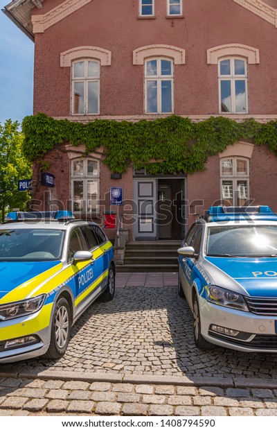 Dannenberg,\
Germany - May 23, 2019: Two German police cars parking in front of\
the police station of a medieval\
city.