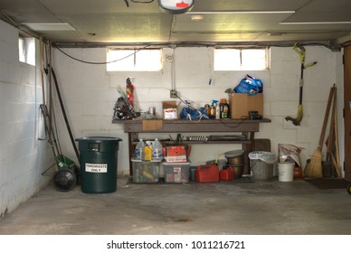 Darien, Illinois, USA, August 14, 2017. The Interior Of An Attached Car Garage On A House Containing Yard Keeping Tools, Cleaning Products, A Trash Can And Miscellaneous Other Items.