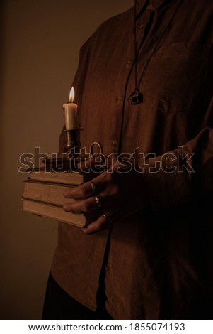Dark academia composition with antique books and candle