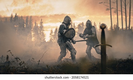 Dark Age Battlefield: Brutal Fight to Death of Two Armored Medieval Knights, Killing Enemy with Sword. Battle of Armed Warrior Soldiers. Dramatic Scene, Cinematic Smoke, Light in Historic Reenactment