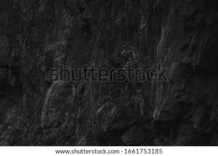 Dark Aged Shabby Cliff Face And Divided By Huge Cracks And Layers. Coarse, Rough Gray Stone Or Rock Texture Of Mountains, Background And Copy Space For Text On Theme Geology. Selective Focus.