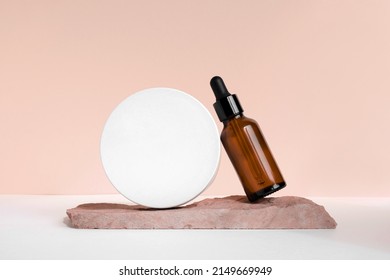 Dark amber glass bottle standing on stone. Natural skin care SPA beauty product design. Mineral organic oil cosmetics on beige background. Mock-Up. Oily pipette. Face and body treatment. Front view. - Shutterstock ID 2149669949