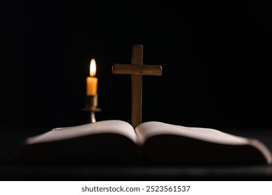 Dark, an antique candle cast its light on the old Bible, its flames flickering gently over the book on the table, symbolizing the enduring essence of religion. candle, bible, dark, light, book, old. - Powered by Shutterstock