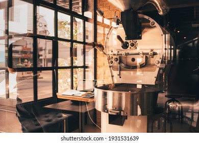 Dark and aromatic coffee beans in a modern roasting machine with the professional coffee roaster  - Powered by Shutterstock