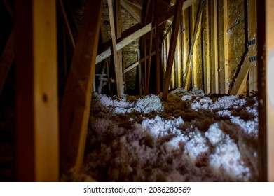 Dark Attic With Loose Blown Insulation Seen Throughout. 