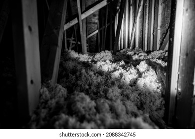 Dark Attic With Loose Blown Insulation Seen Throughout. 