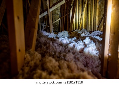 Dark Attic With Loose Blown Insulation Seen Throughout. 