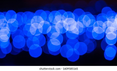 Dark background with blur blue light circles. Abstract defocused pattern