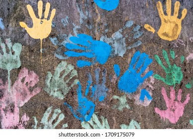 Dark background with colorful handprints symbolising interracial friendship - Shutterstock ID 1709175079