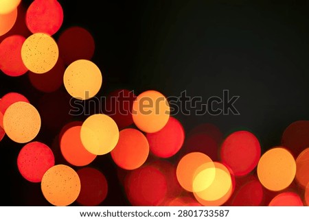 A dark background filled with out-of-focus red and orange bokeh lights, creating a festive and warm atmosphere.