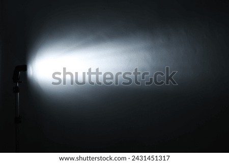 A dark background with a light source speedlite flash