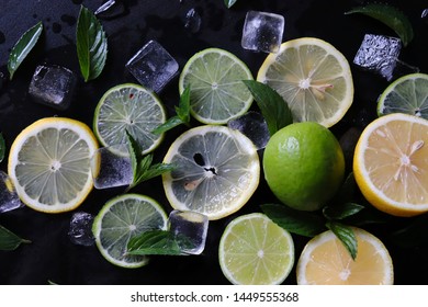 Dark Background With Sliced Citrus, Mint And Ice. Sprayed A Refreshing Drink Of Lemon, Lime And Mint And Ice Cubes. An Explosion Of Fruit.