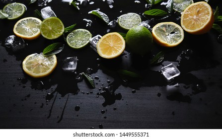 Dark Background With Sliced Citrus, Mint And Ice. Sprayed A Refreshing Drink Of Lemon, Lime And Mint And Ice Cubes. An Explosion Of Fruit.