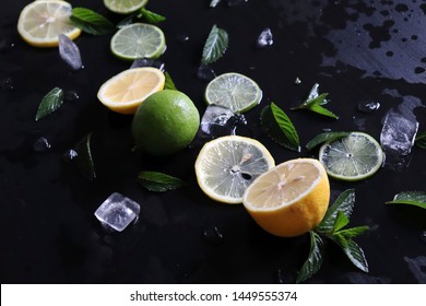 Dark Background With Sliced Citrus, Mint And Ice. Sprayed A Refreshing Drink Of Lemon, Lime And Mint And Ice Cubes. An Explosion Of Fruit.