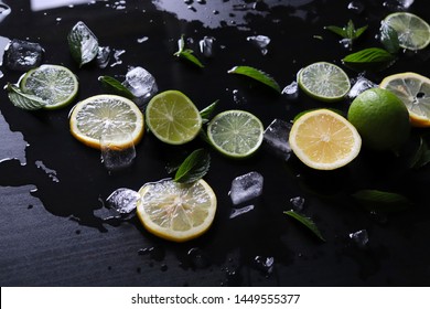 Dark Background With Sliced Citrus, Mint And Ice. Sprayed A Refreshing Drink Of Lemon, Lime And Mint And Ice Cubes. An Explosion Of Fruit.