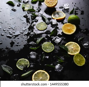 Dark Background With Sliced Citrus, Mint And Ice. Sprayed A Refreshing Drink Of Lemon, Lime And Mint And Ice Cubes. An Explosion Of Fruit.