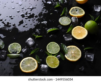 Dark Background With Sliced Citrus, Mint And Ice. Sprayed A Refreshing Drink Of Lemon, Lime And Mint And Ice Cubes. An Explosion Of Fruit.