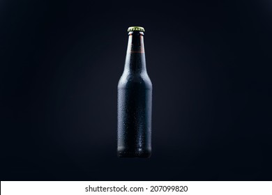 Dark beer in bottle isolated black gradient background