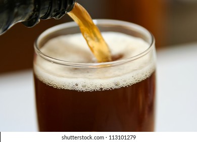 Dark Beer Is Pouring Into A Glass, Close Up