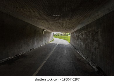 A dark bike underpass with a curve in the end of the tunnel. - Powered by Shutterstock